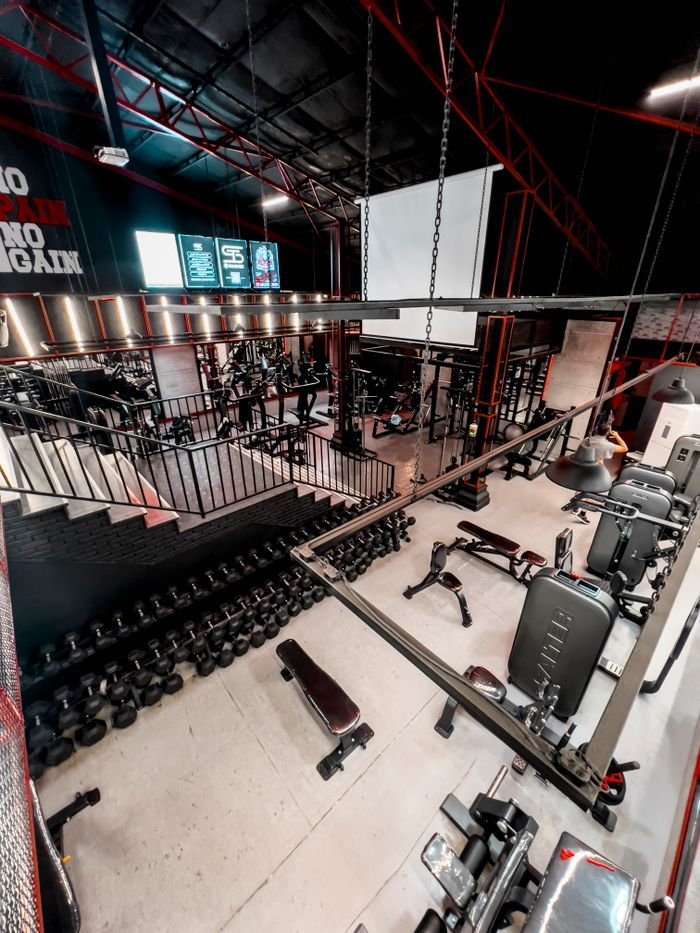 Services Spacious gym interior featuring a variety of fitness equipment and weights, perfect for workouts.