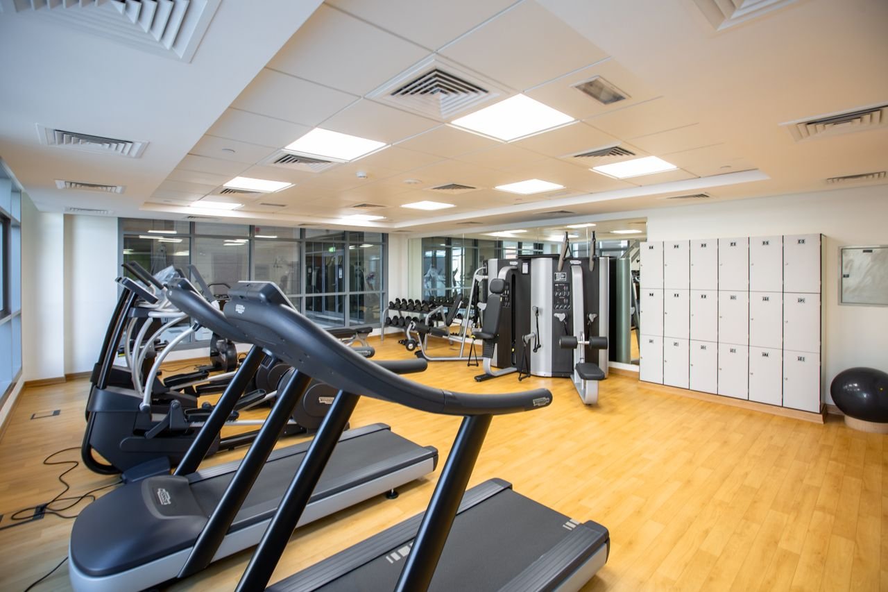 Home Spacious gym interior featuring treadmills, fitness machines, and lockers.